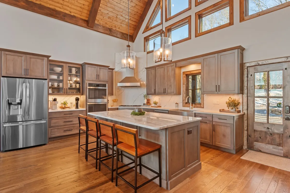 A close-up view of the kitchen island, surrounded by large windows and equipped with stainless steel appliances. The layout encourages interaction and makes the kitchen a hub for entertaining and culinary adventures.